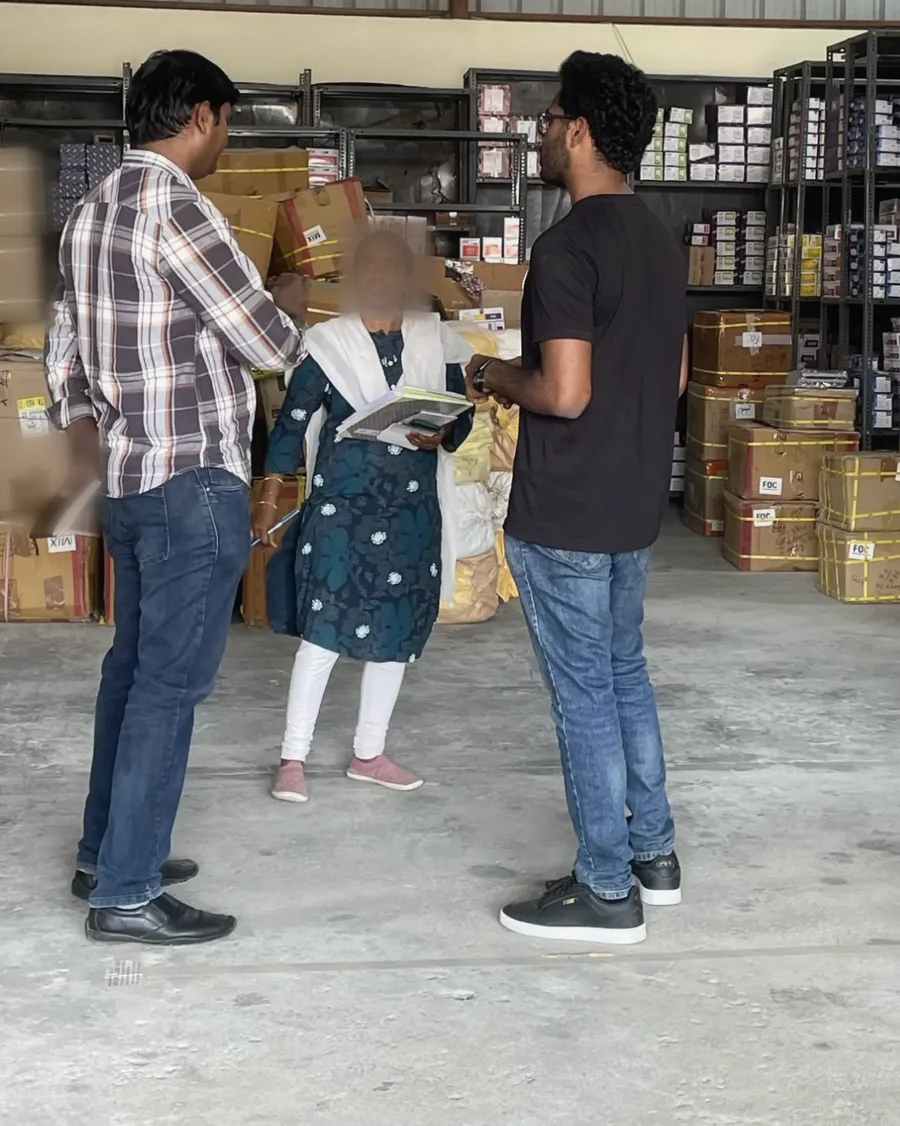The author and a PIPRA colleague talk with a staff member holding a notebook and papers, whose face is blurred.